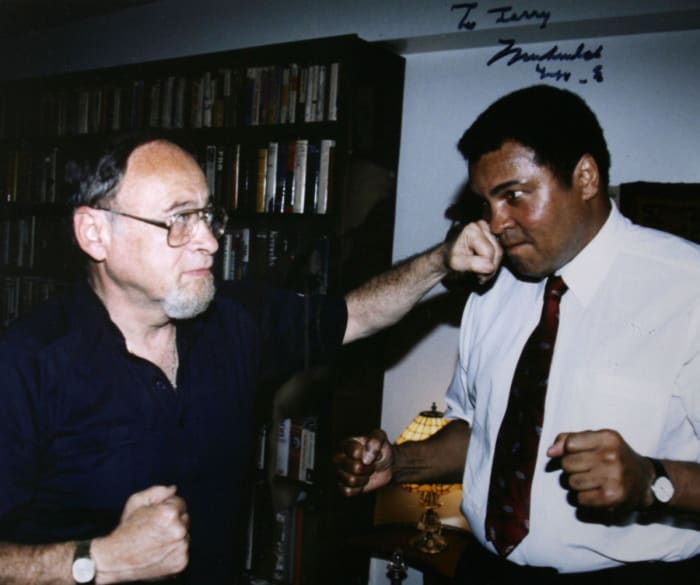 Sports writer Jerry Izenburg lands a friendly punch on Muhammad Ali.